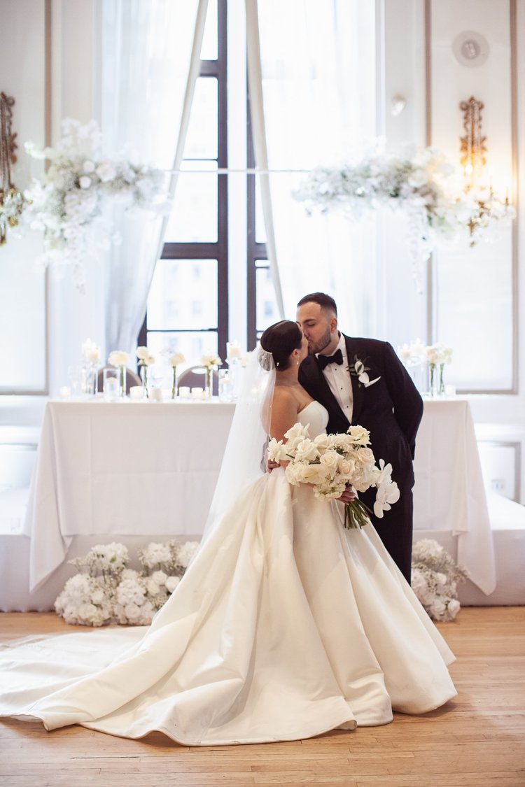 A bride and groom sharing a kiss at their wedding ceremony.