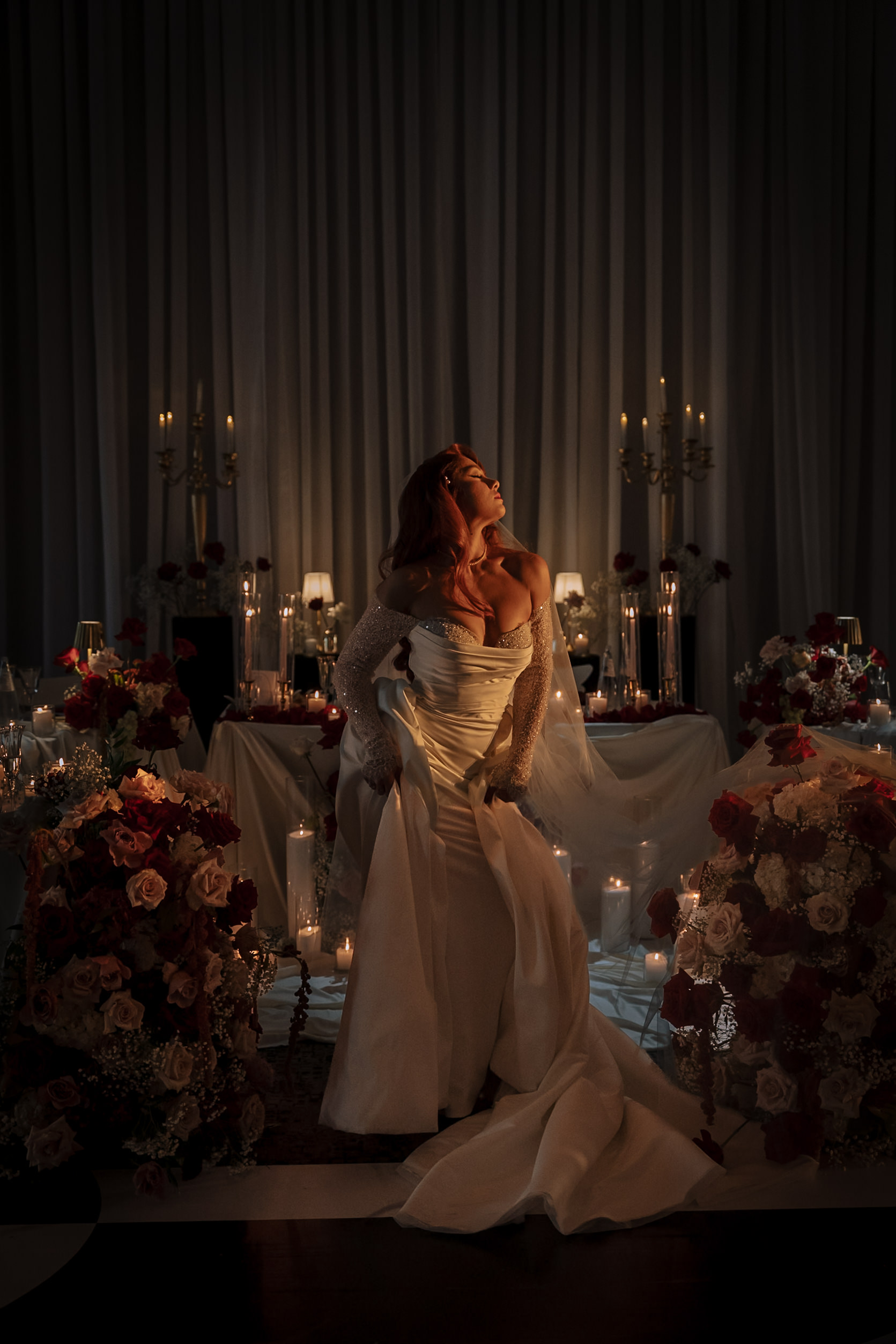 Bride in a candlelit wedding reception with sculptural floral arrangements by Alexandria Design House